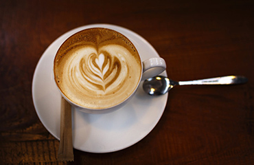 a tray with a cup of coffee and a glass of water